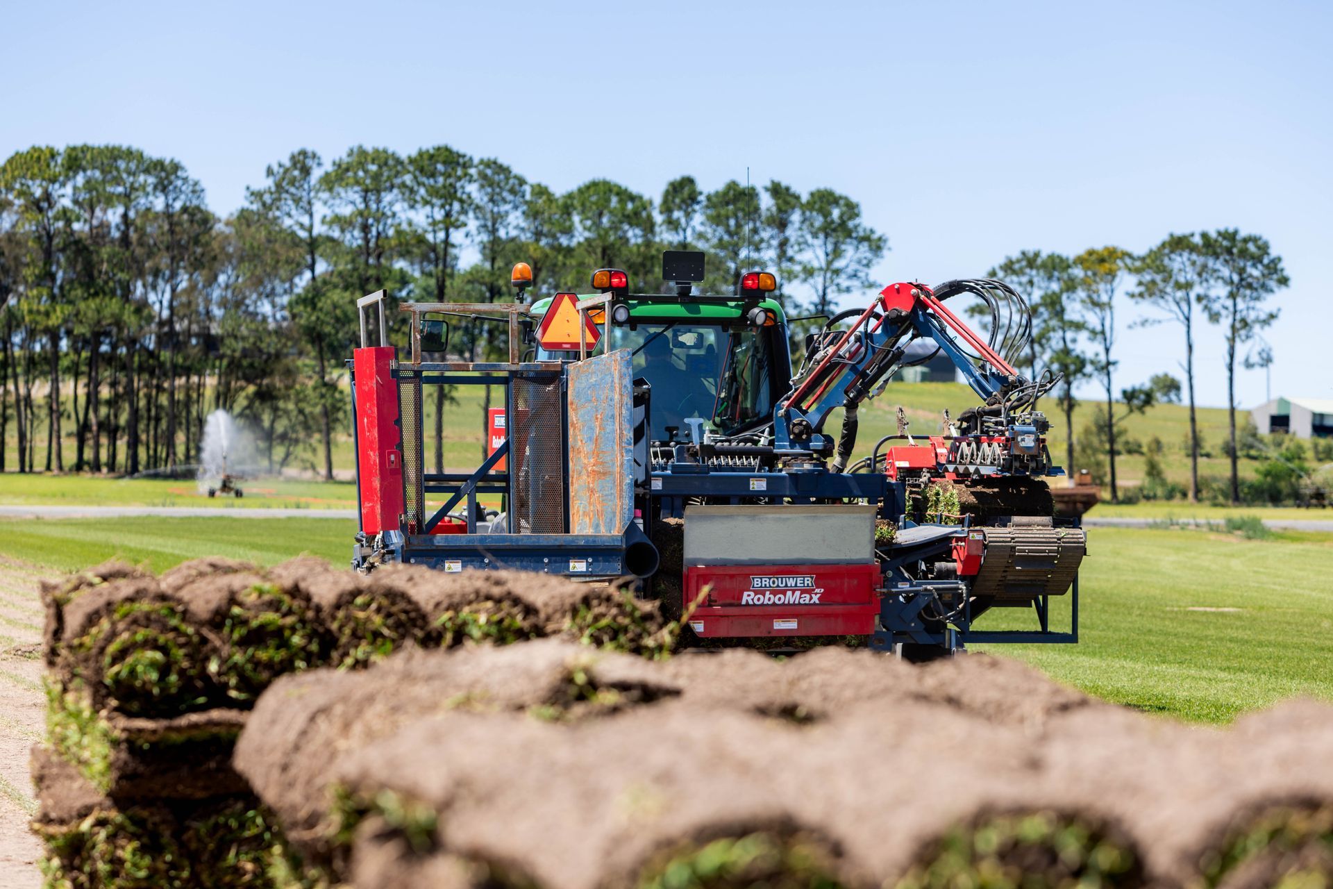 Rolls of fresh green sod stacked on top of each other with grass background.
