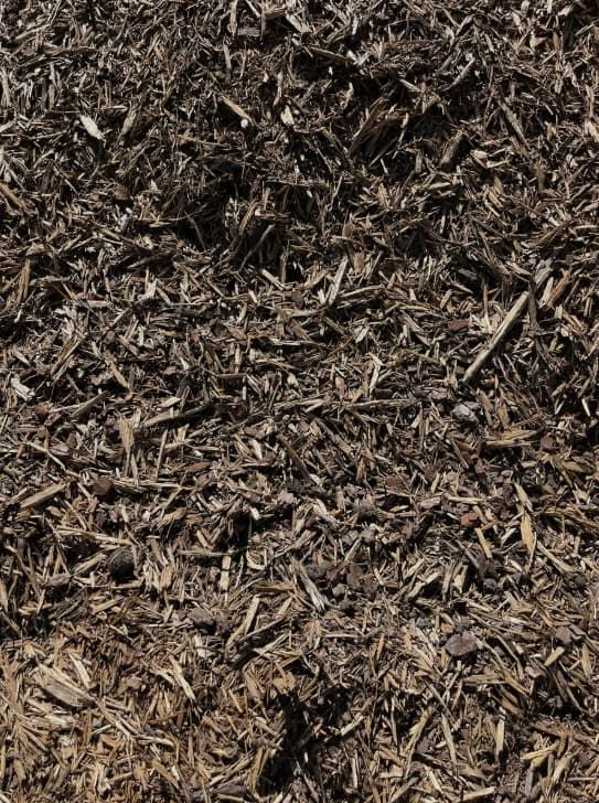 Dark brown wood mulch, a landscaping material.