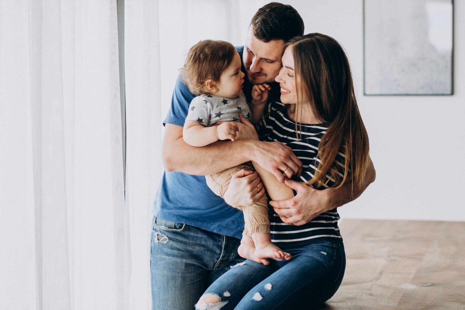 A man and a woman are holding a baby in their arms.