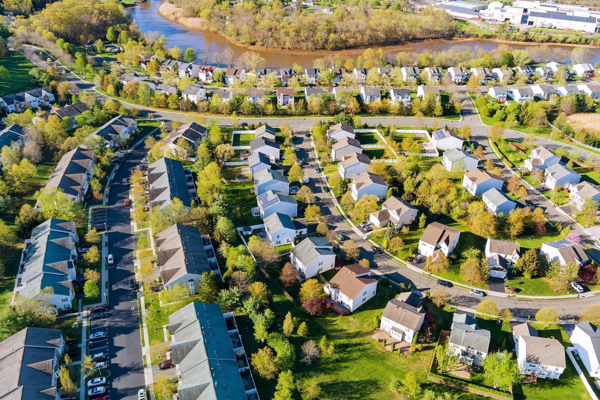Aerial view of a suburban neighborhood with rows of houses and autumn trees.
