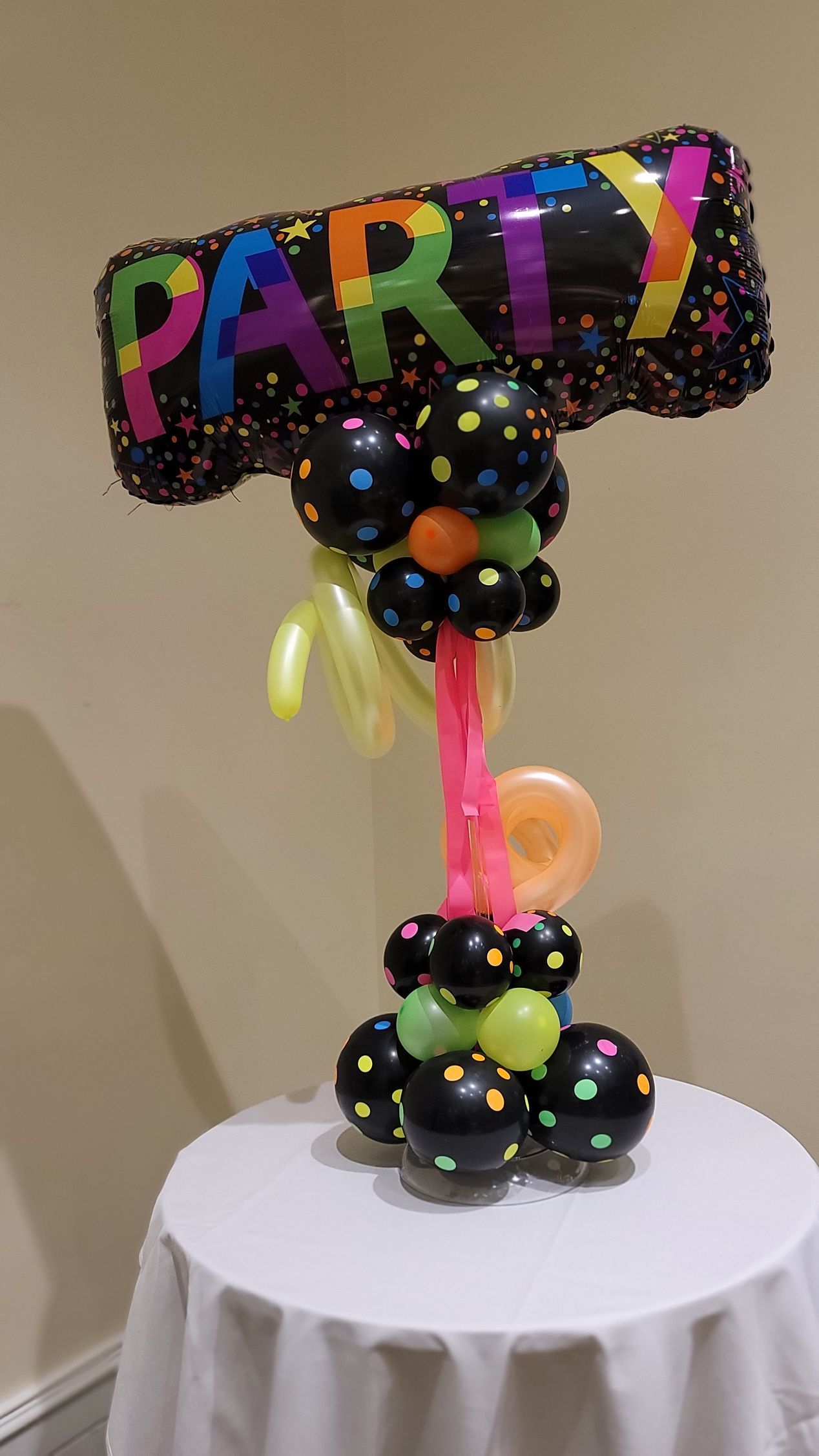 a table with balloons and a balloon that says party on it .