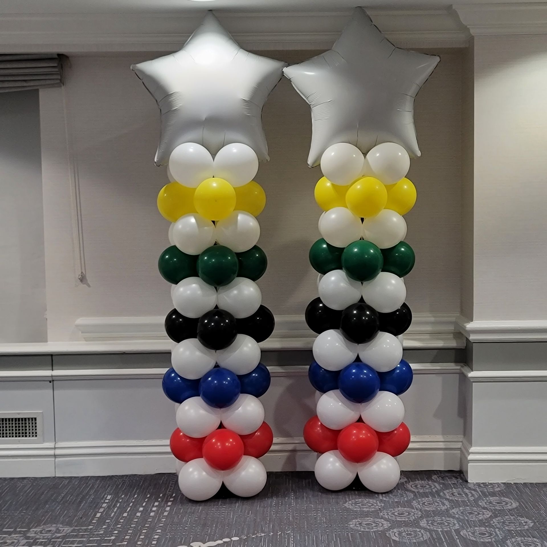 two columns of balloons with stars on top of them