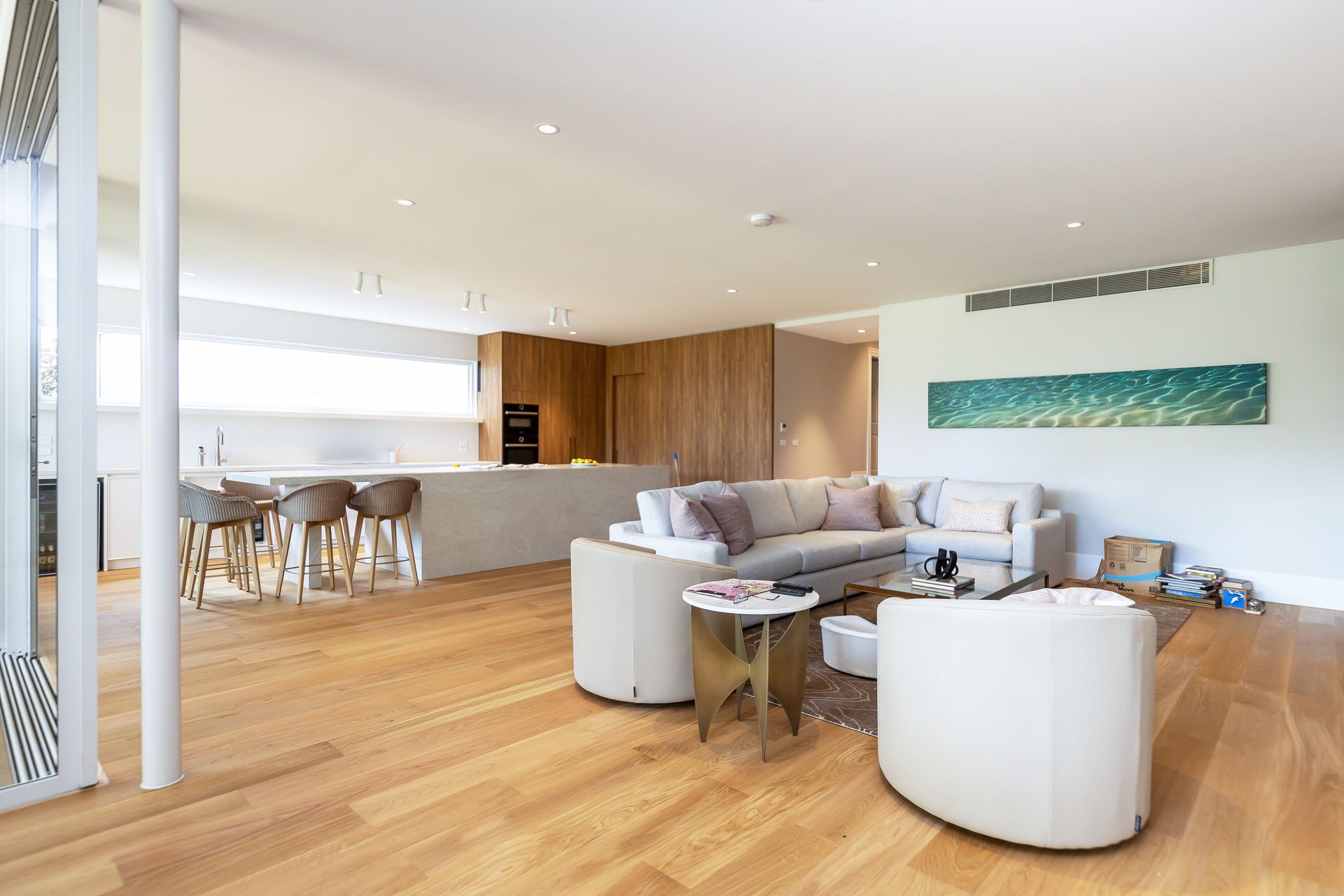 A living room with a couch, chairs, and a table.