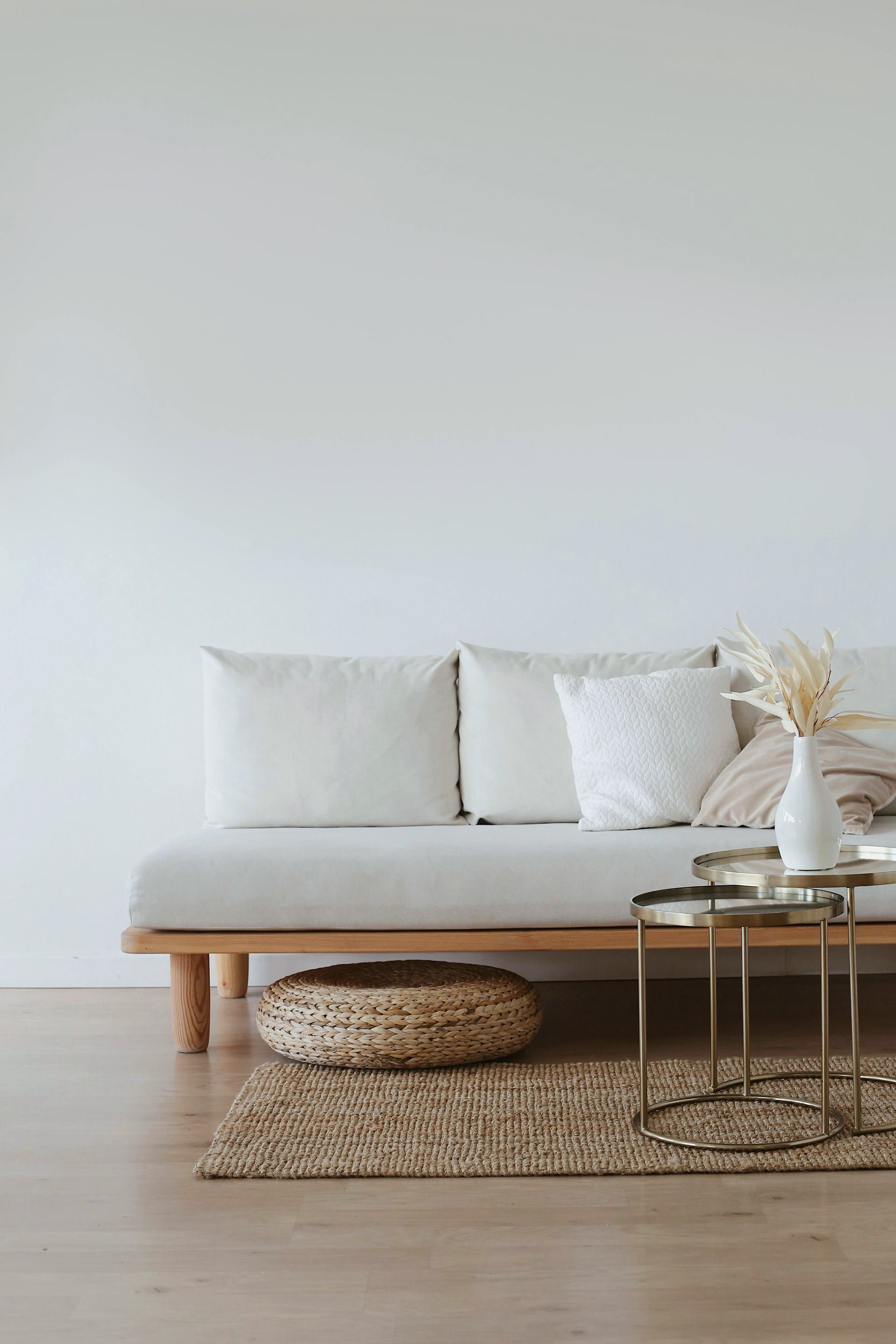 A living room with a couch , two tables , and a rug.