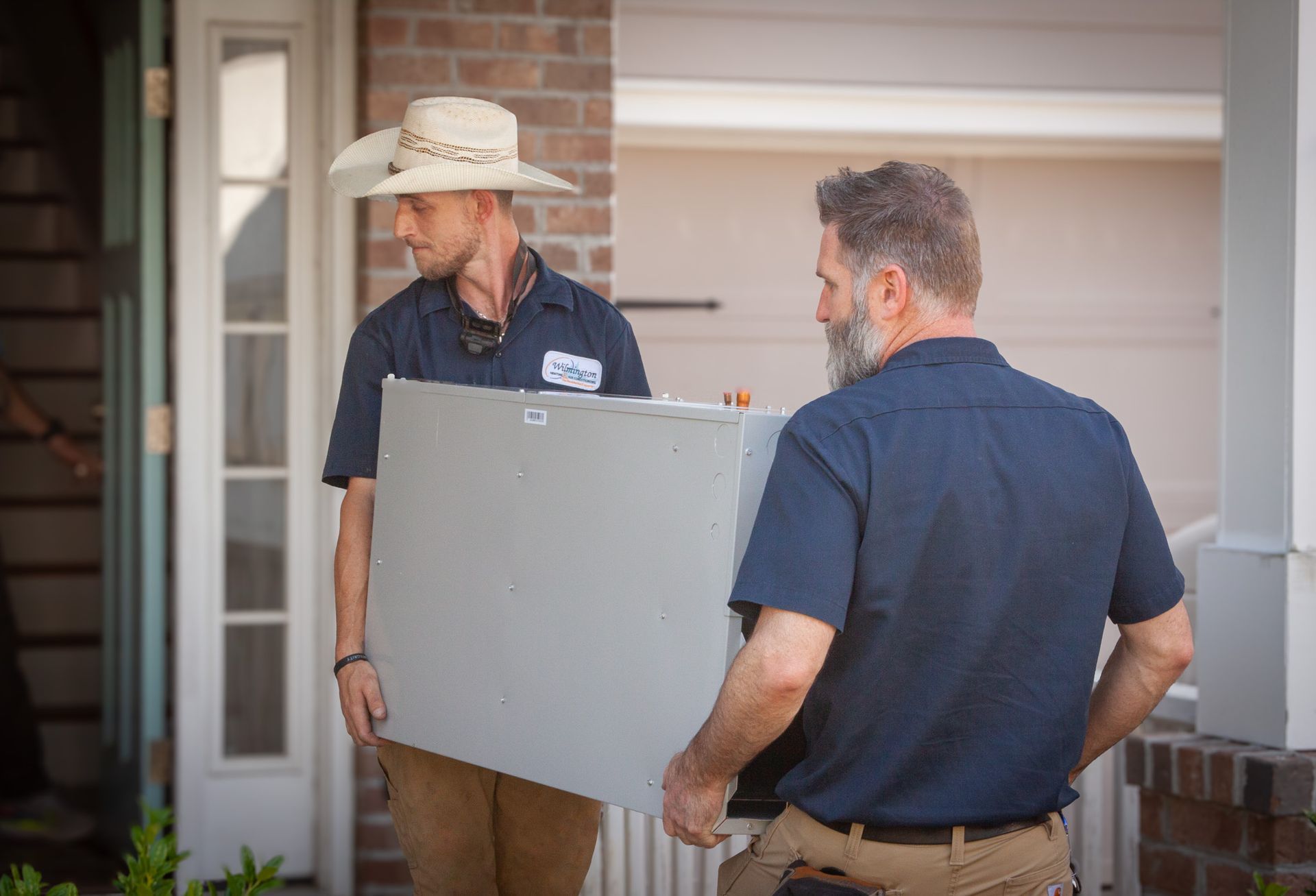 A man is fixing a boiler with a wrench and a towel. Heat Pump Air Handler Installation Wilmington NC