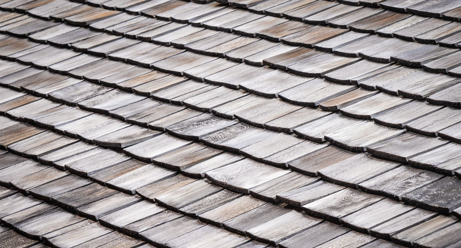 Diagonal view of gray shingle roof tiles with alternating light and dark rows