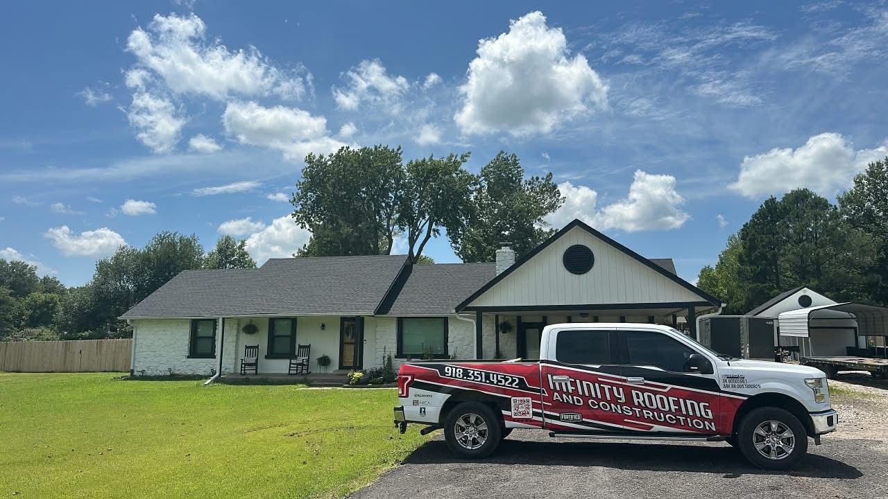 Parked red-and-black service truck in front of a single-story house on a sunny lawn