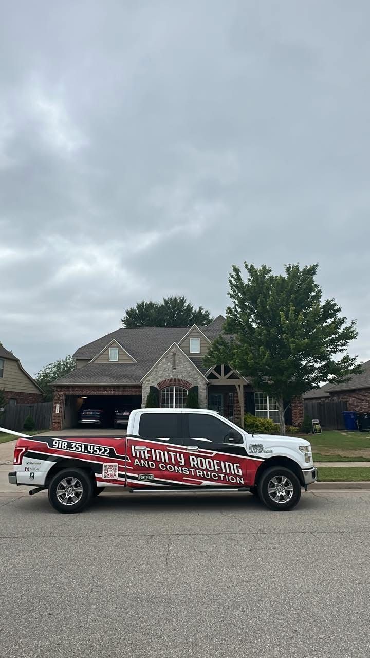 Red and white pickup truck with bold graphics parked on a suburban street under cloudy skies