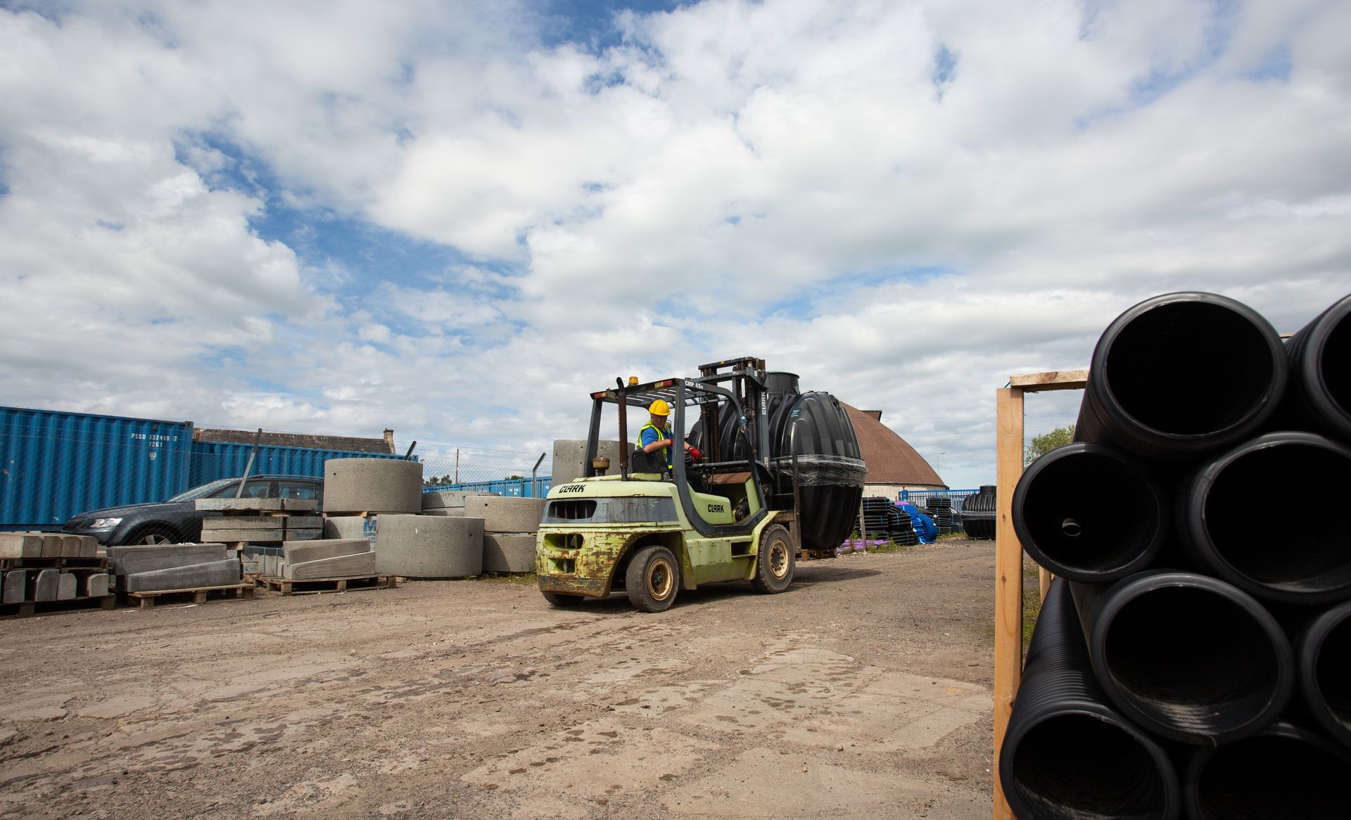 A man is driving a forklift in a construction site.