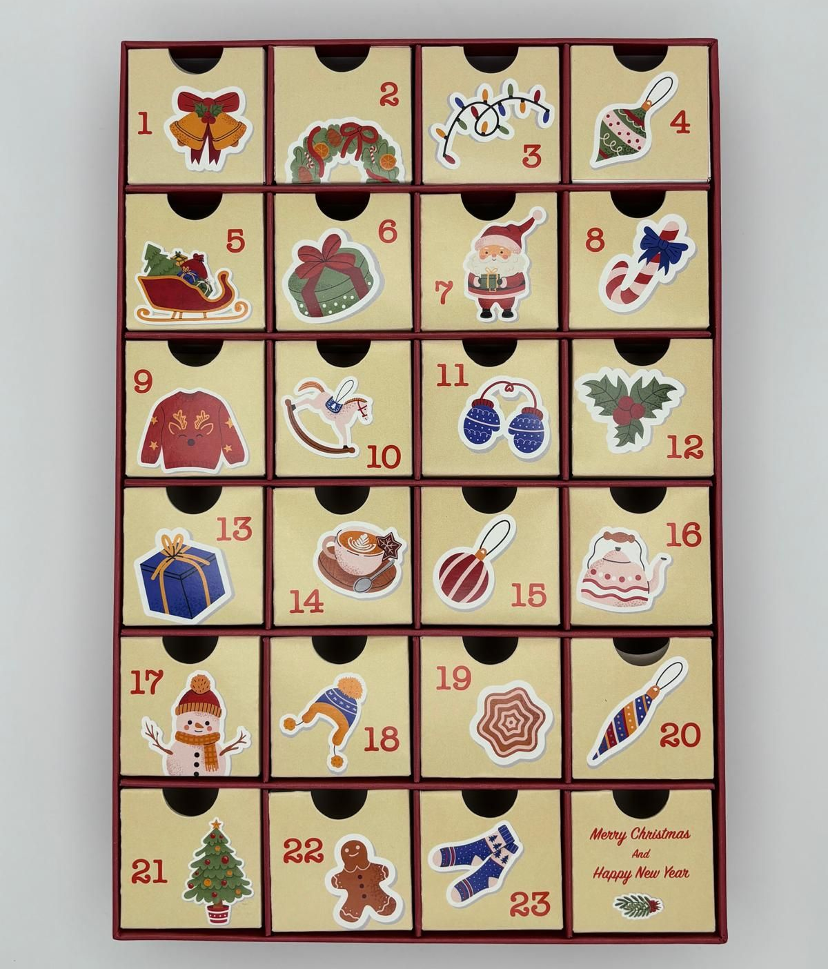 Persona che tiene in mano una scatola di biscotti a forma di stella disposti a forma di corona, con un fiocco dorato, davanti a un albero di Natale.