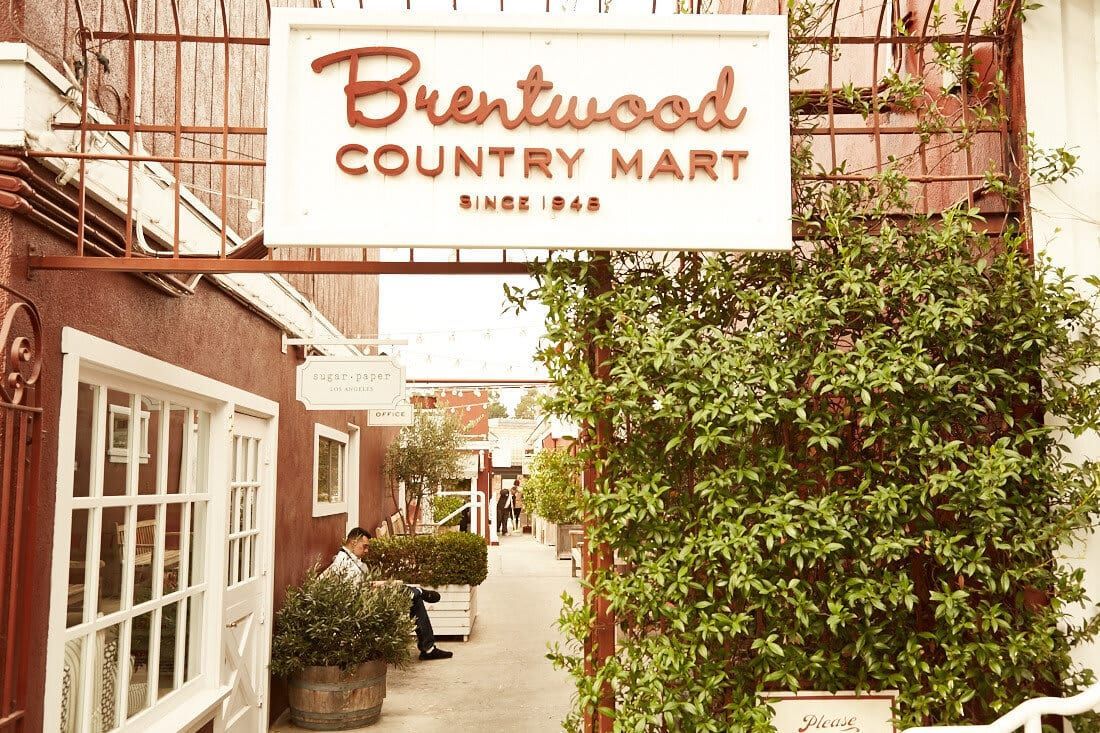 Brentwood Country Mart with brown gated fence and greenery, buy a home in Brentwood | Lisa Kirshner Properties