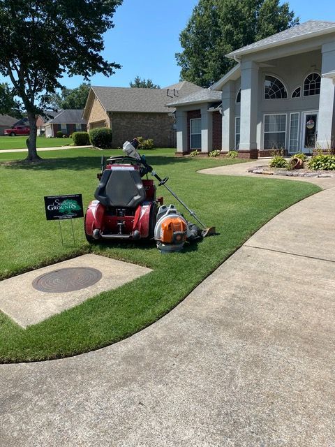 a lawn mower is parked in front of a house.