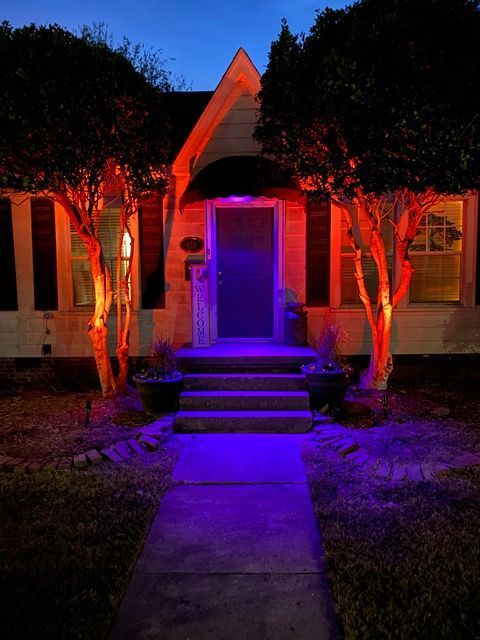 the front of a house is lit up with purple lights.