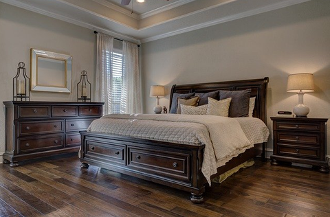 Bedroom routinely cleaned with bed made, and floor polished.