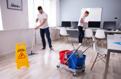 Janitors mopping commercial building and dusting computer desk
