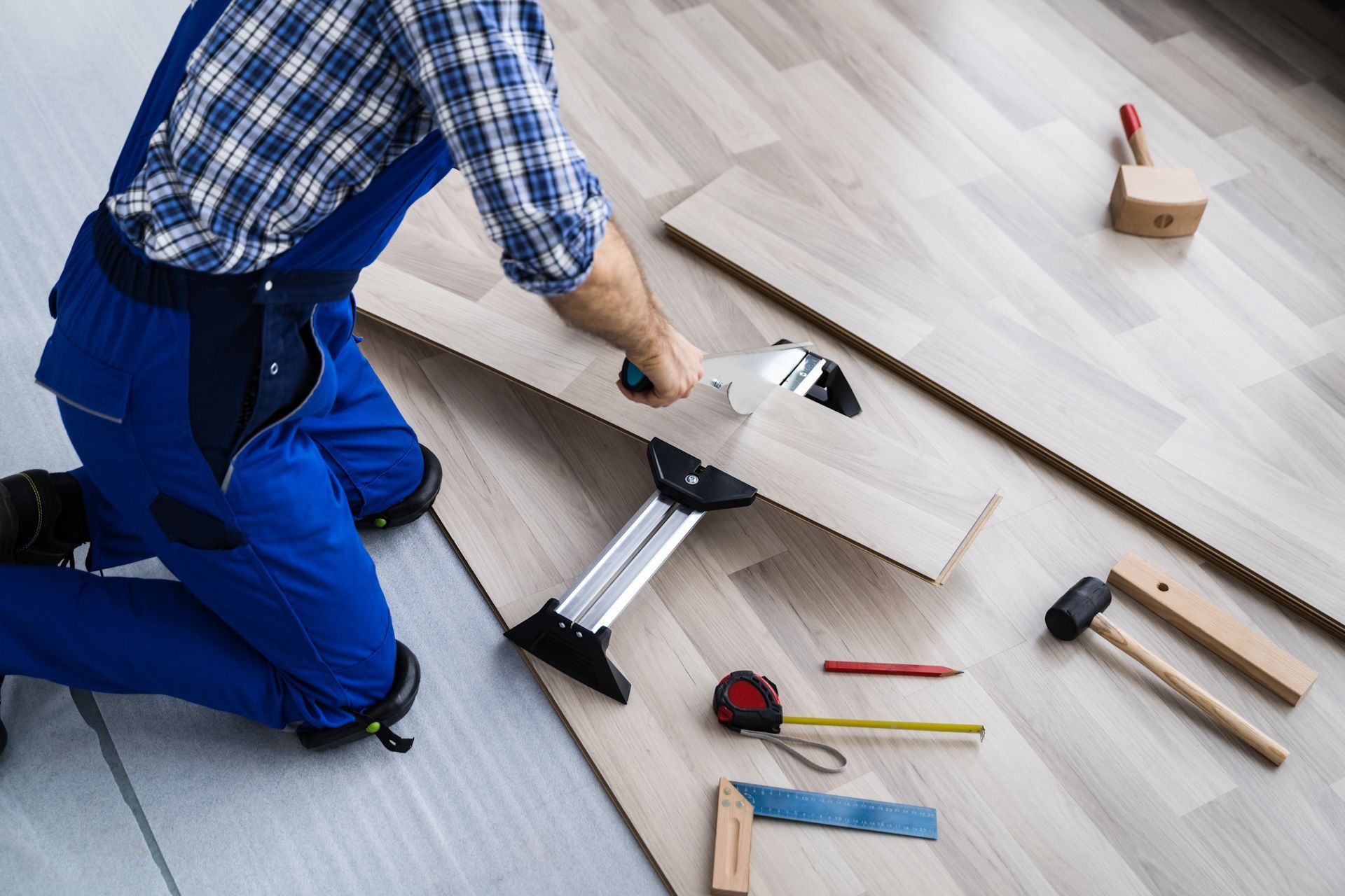 A man is cutting a piece of wood with a saw.