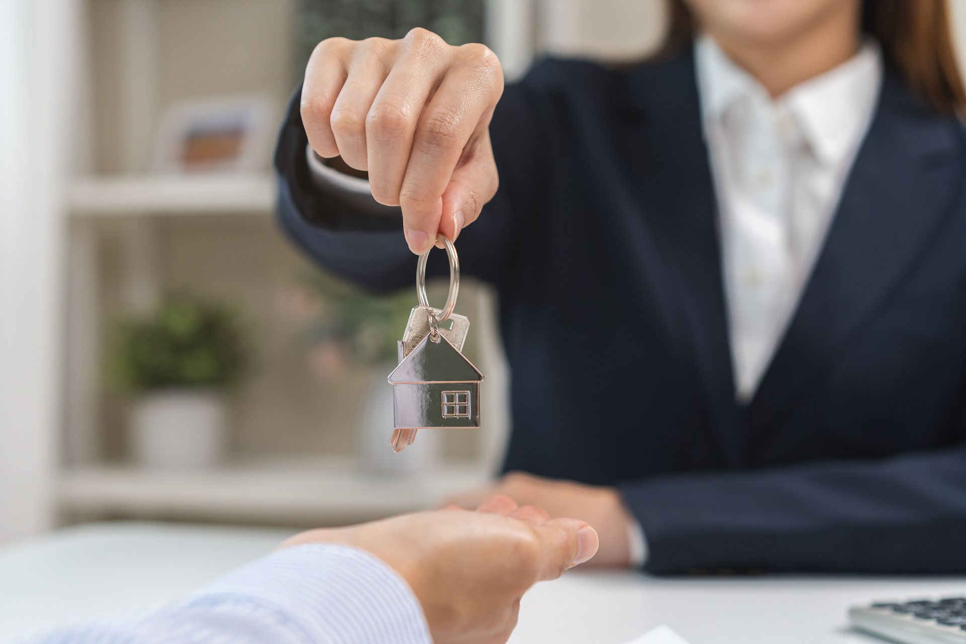 A woman is giving a set of keys to a man.
