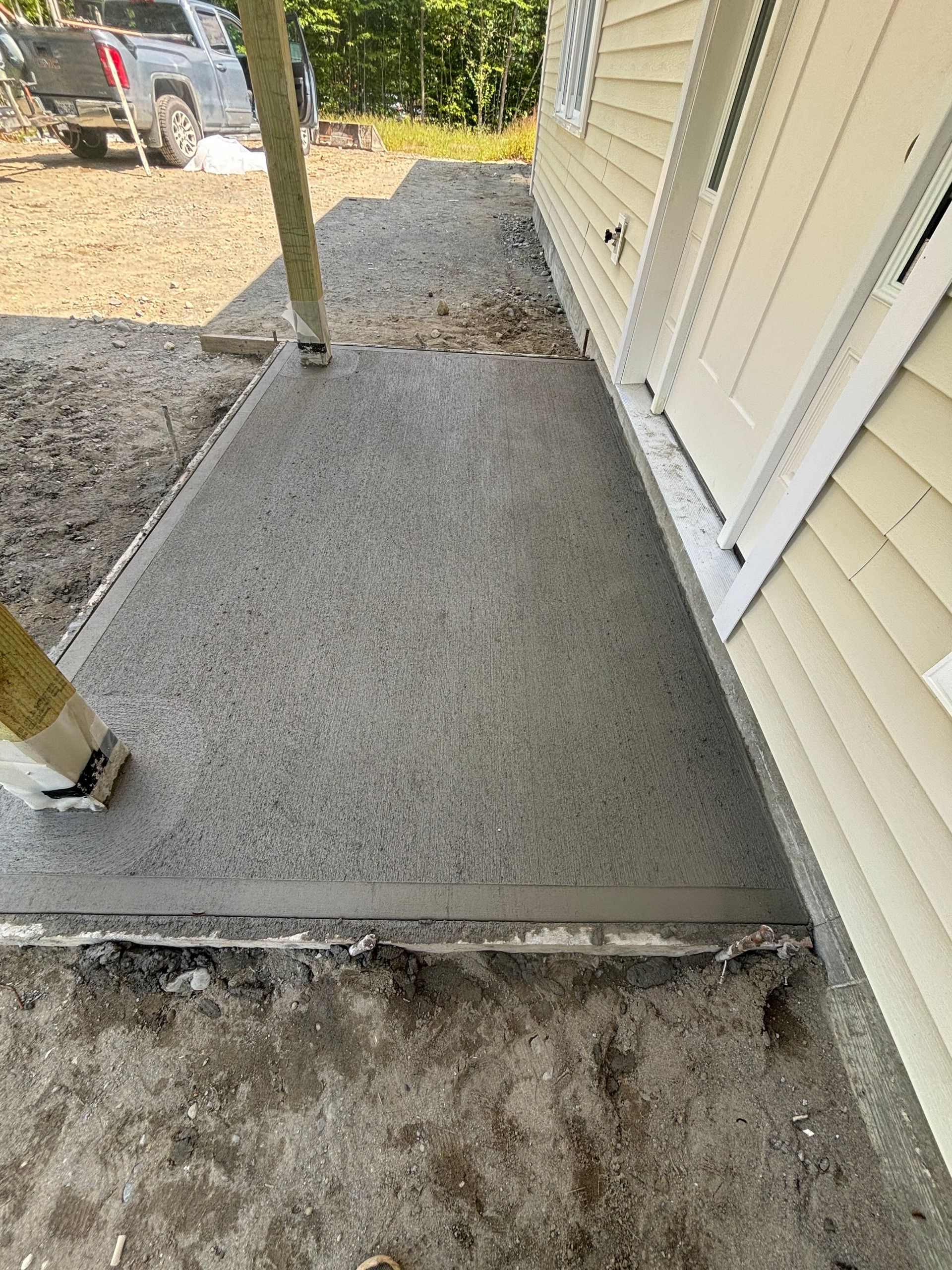 A concrete walkway is being built in front of a house.