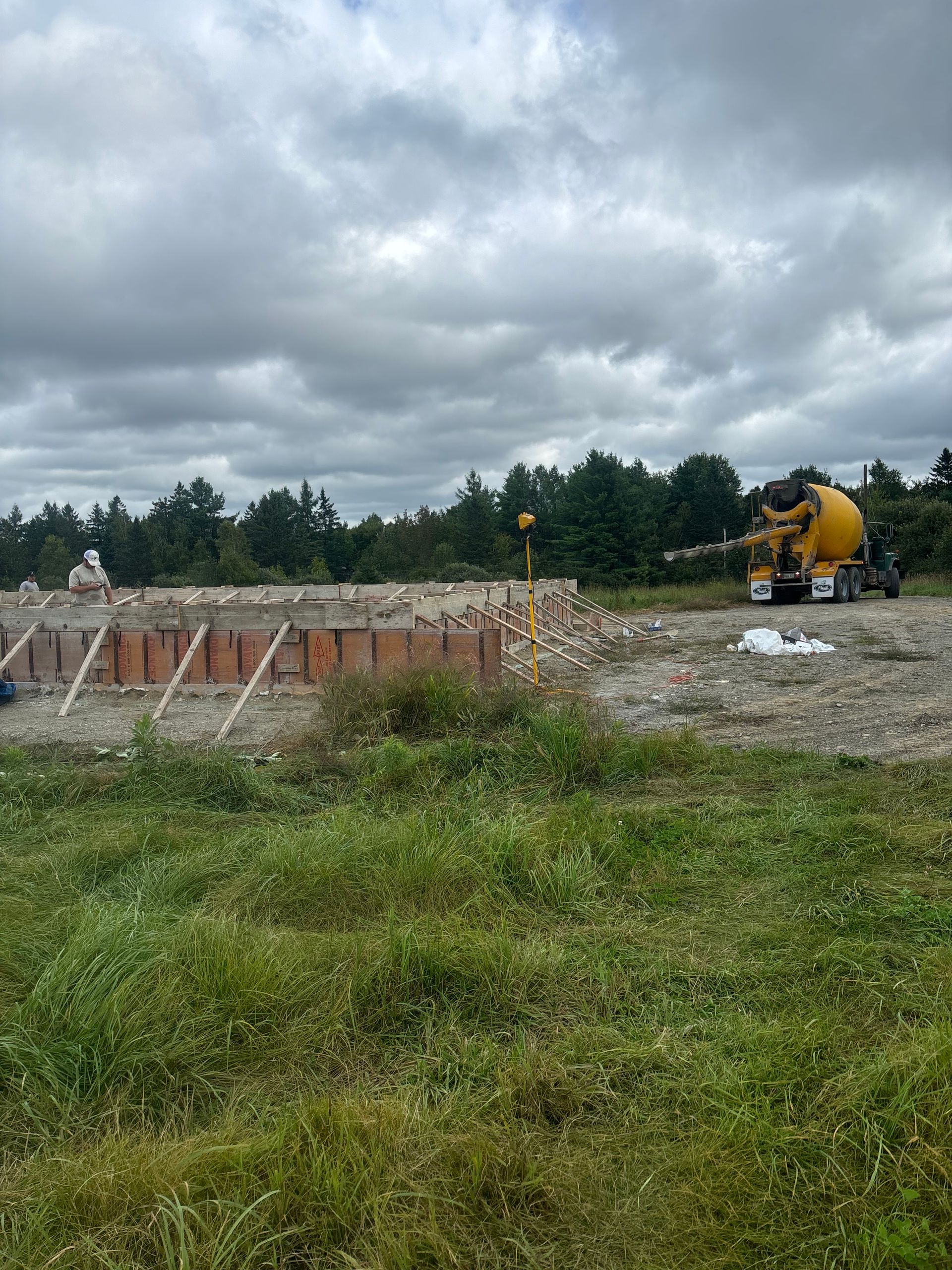 A concrete mixer is pouring concrete into a field.