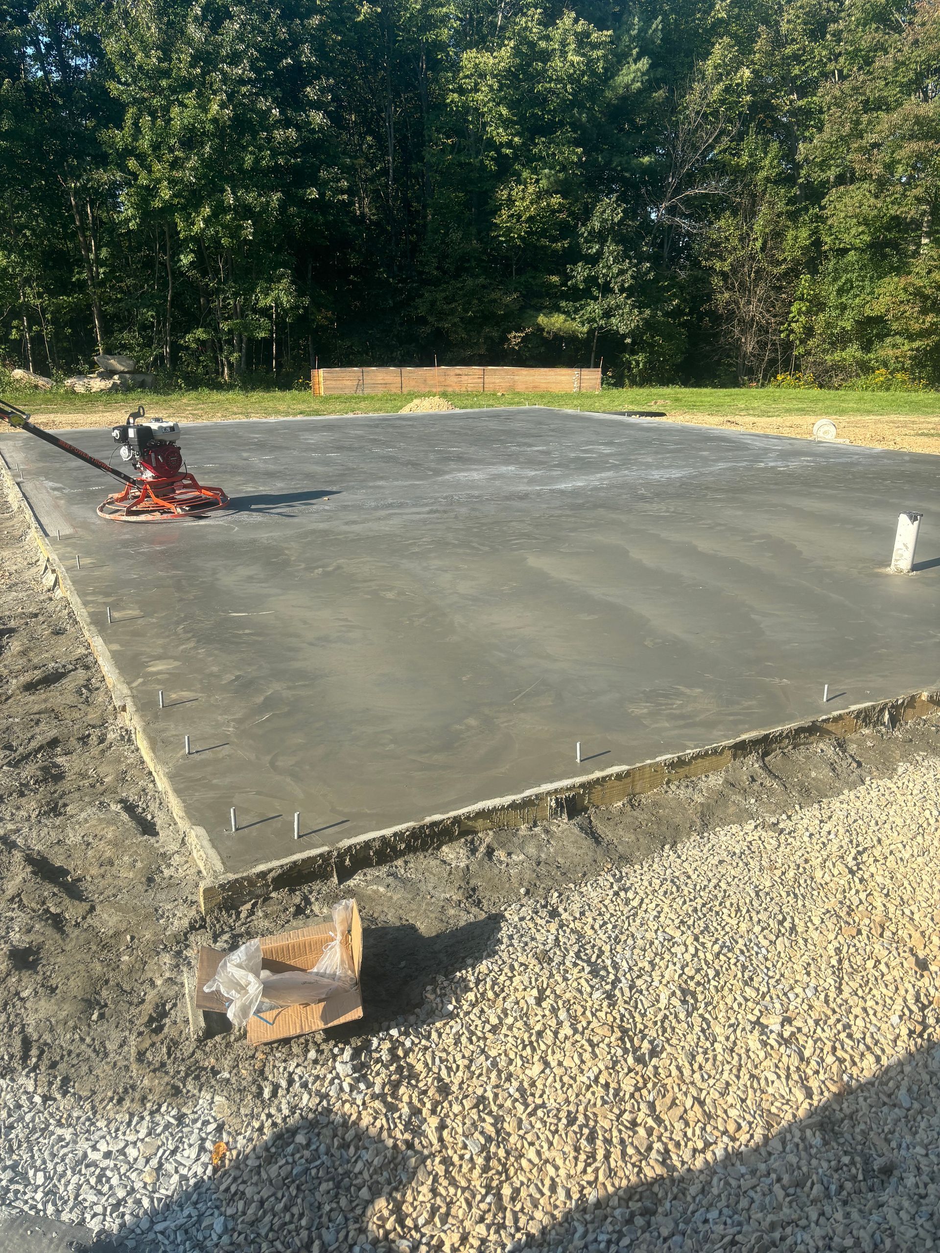 A concrete slab is being built in a backyard.