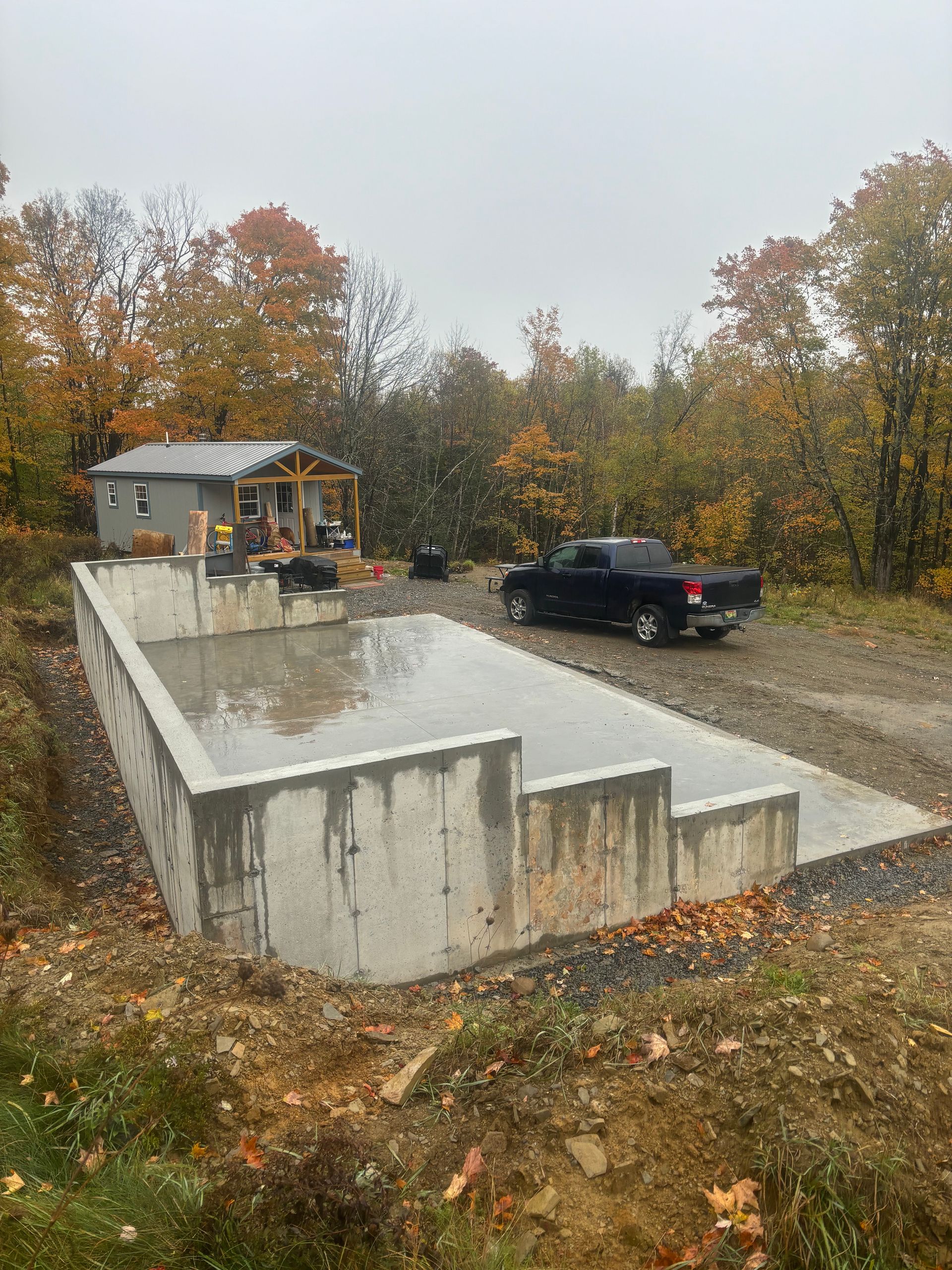 A truck is parked in front of a large concrete foundation.