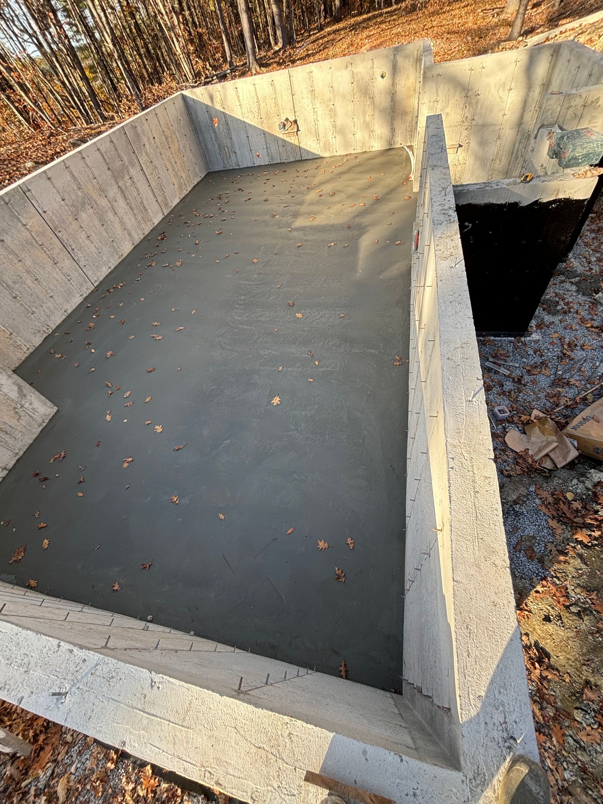 A large concrete foundation is being built in the woods.