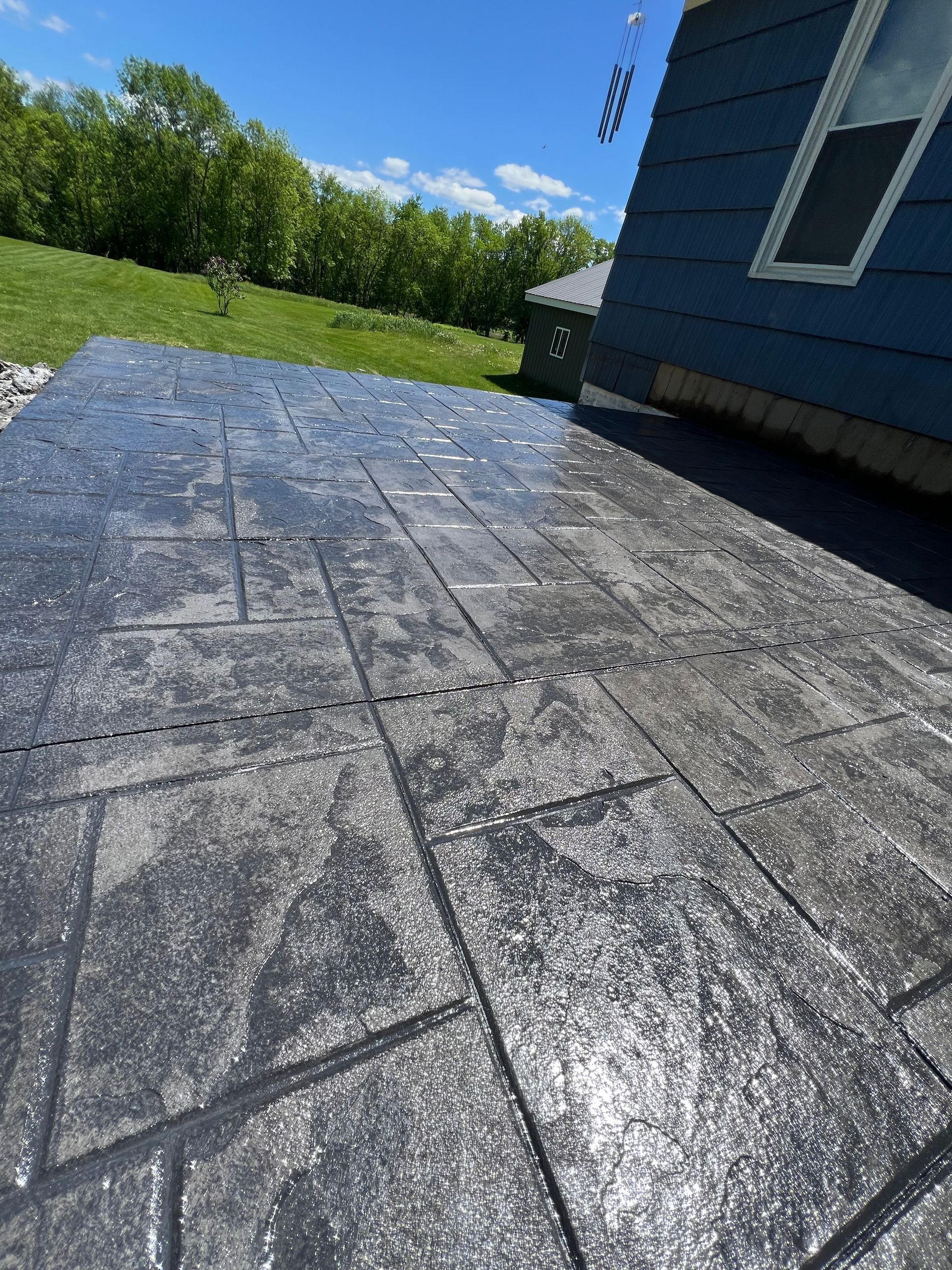 A concrete patio with a blue house in the background.
