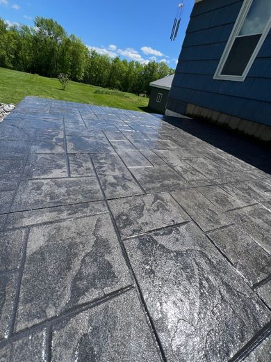 A concrete patio with a blue house in the background.