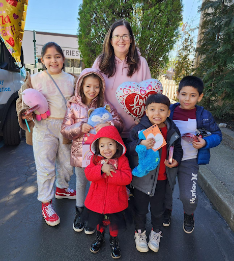 A group of children are posing for a picture with a woman.