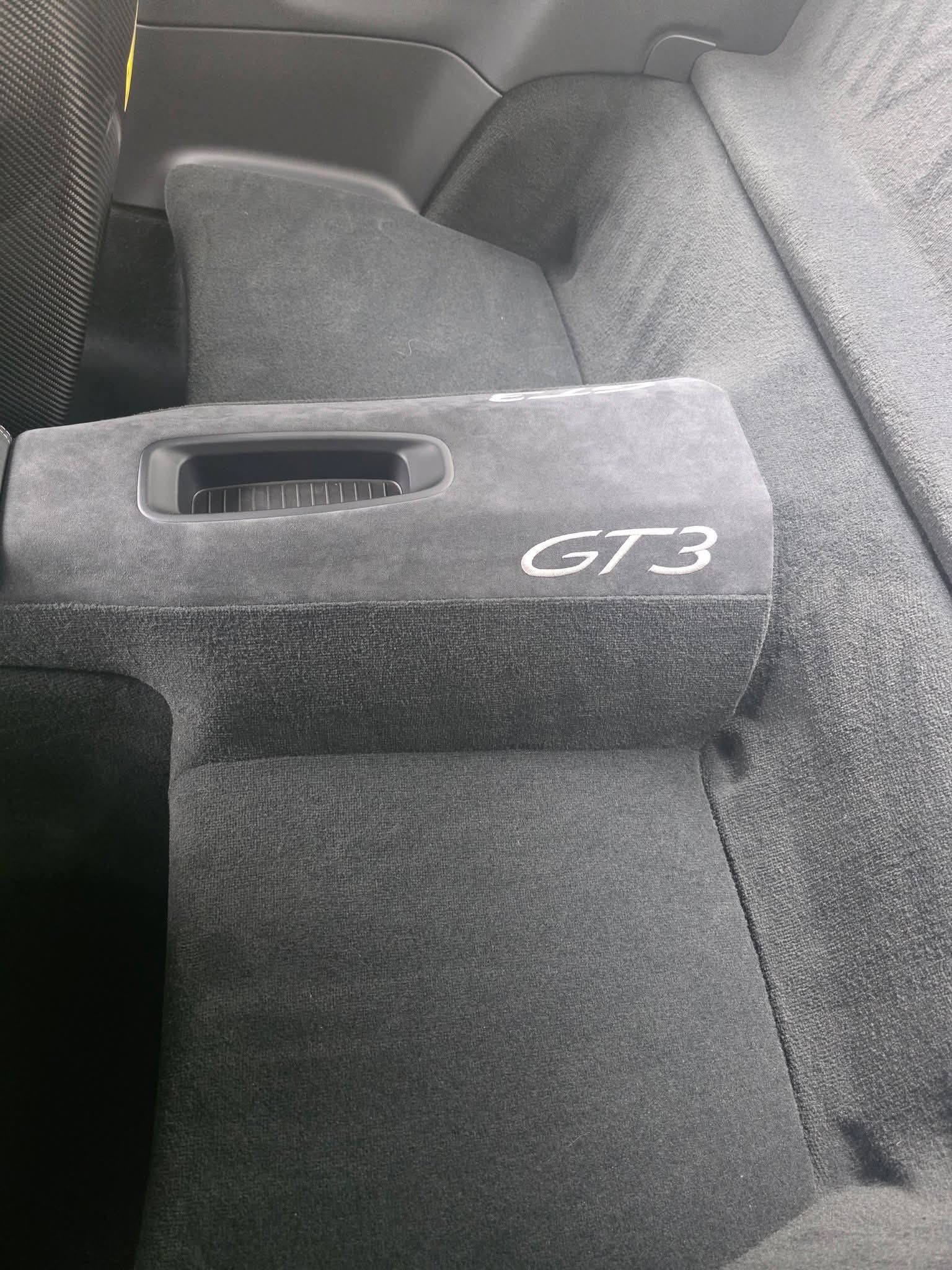 Gray GT3 racing seat interior with armrest and seatbelt slot