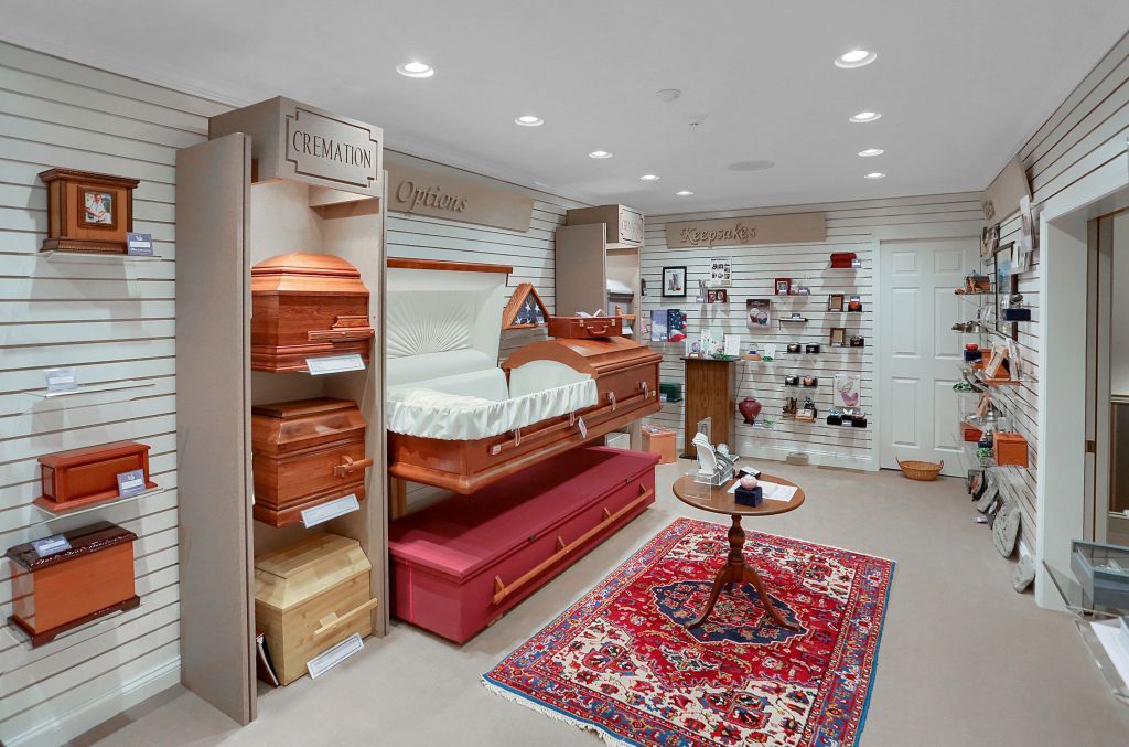 Bright boutique interior with pink seating, patterned rug, and shelves of decorative items