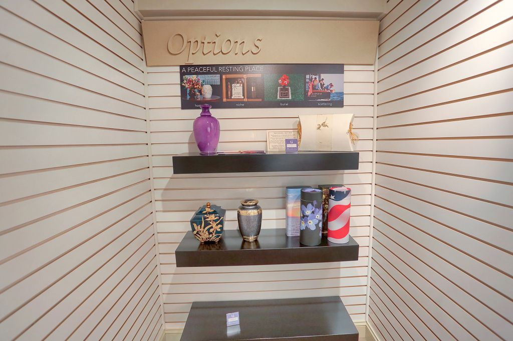 Display with decorative vases, jars, and candles on slatwall shelves