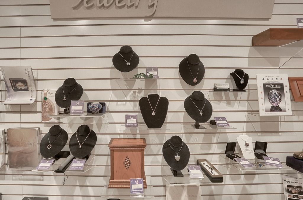 Jewelry display wall with black necklaces, bracelets, and rings on shelves and stands