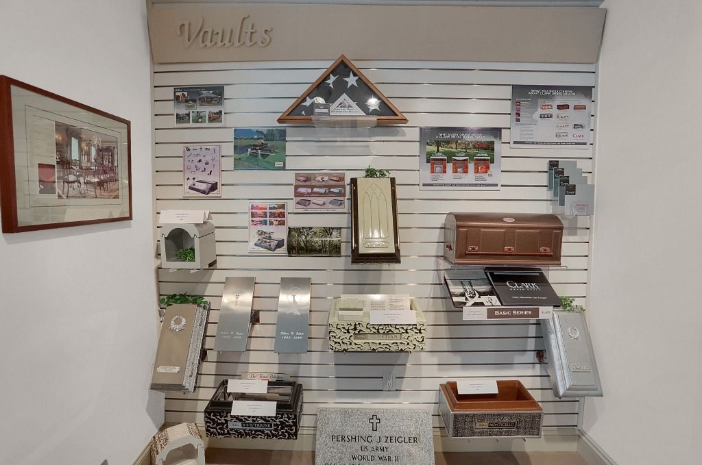 Display wall of building materials with samples, brochures, and a small roof model in a showroom