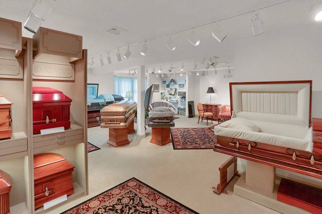 Bright boutique showroom with upholstered furniture, rugs, and display shelves in soft neutral tones.