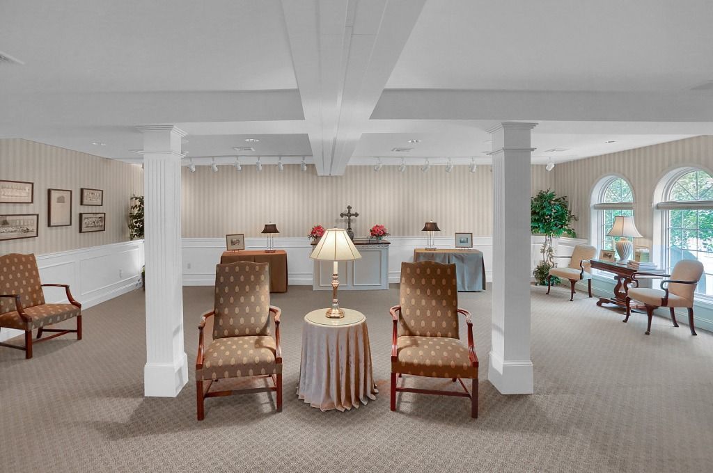 Elegant living room with patterned chairs, side tables, and large windows letting in natural light