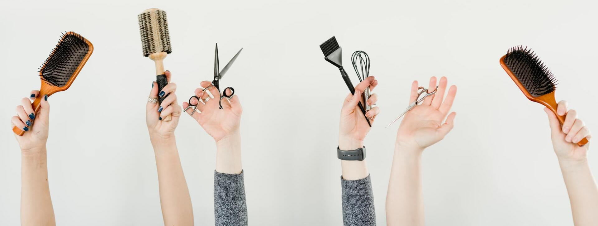 Photo of people's hands holding various hair salon items Photo of people's hands holding various hair salon items
