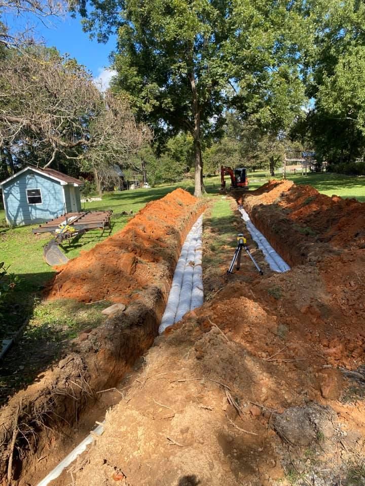 A drainage system is being installed in a backyard.
