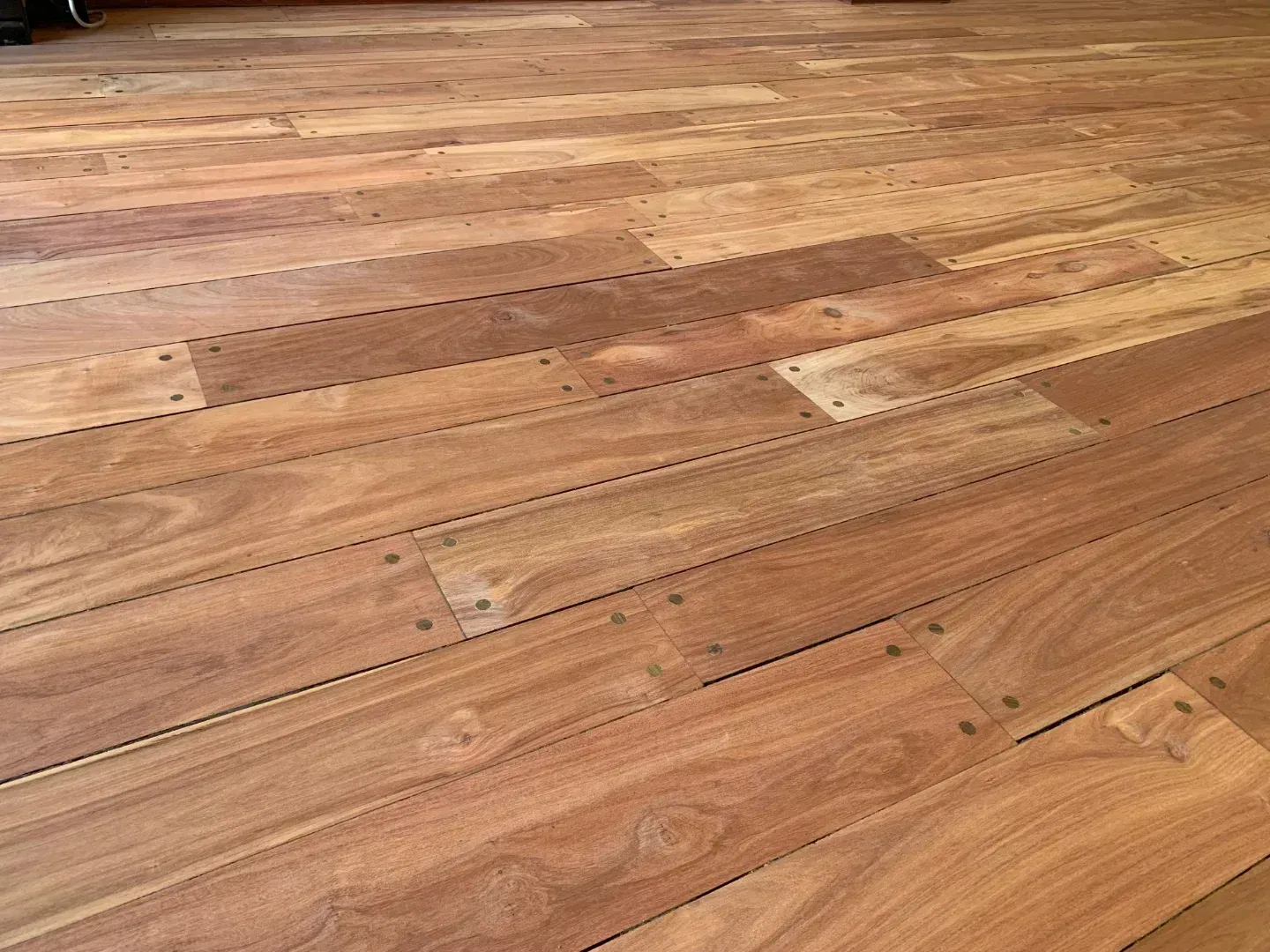 Suelo de tablones de madera con tonos marrones cálidos y vetas visibles.