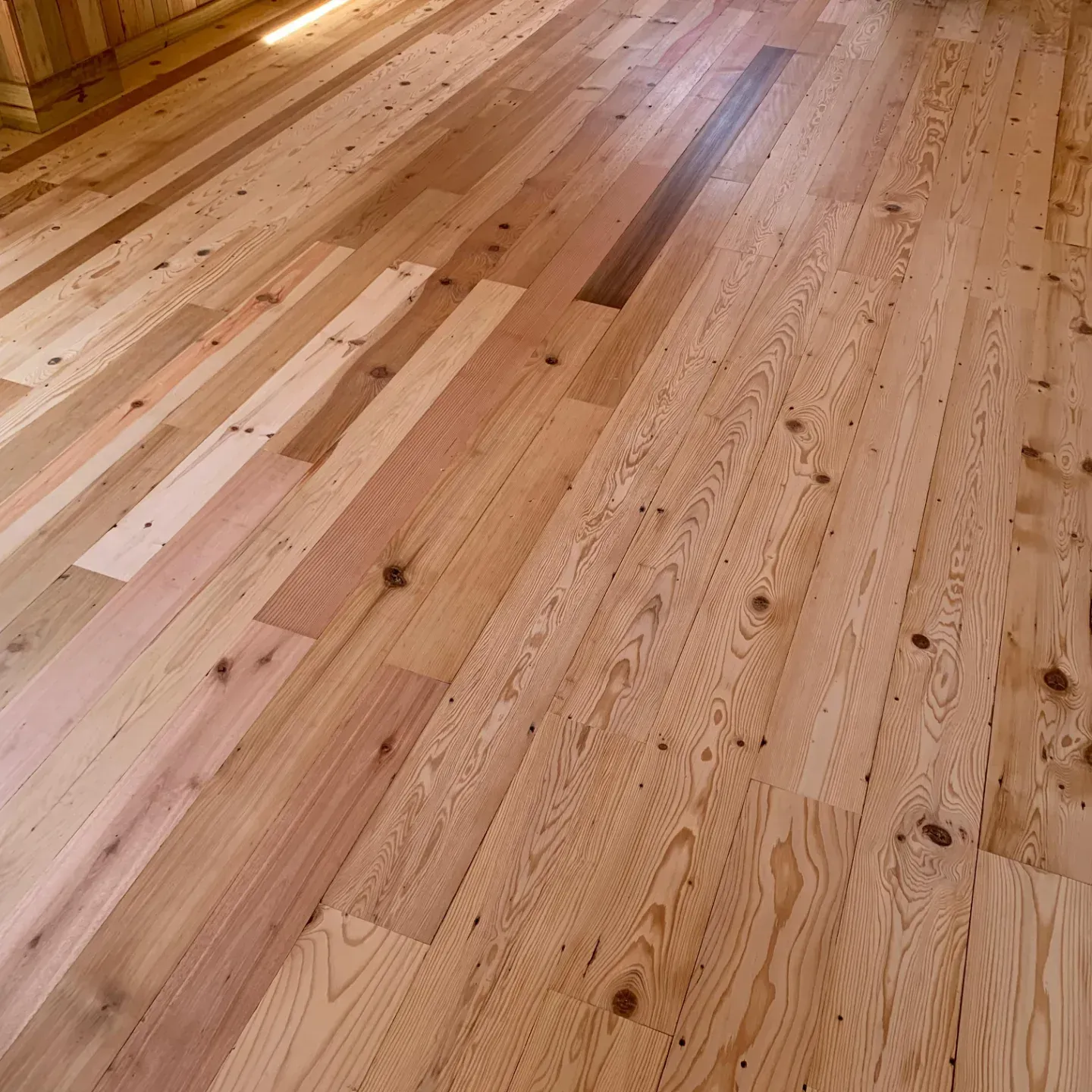 Tablones de madera maciza con vetas variadas y una franja más oscura que recorre el centro.