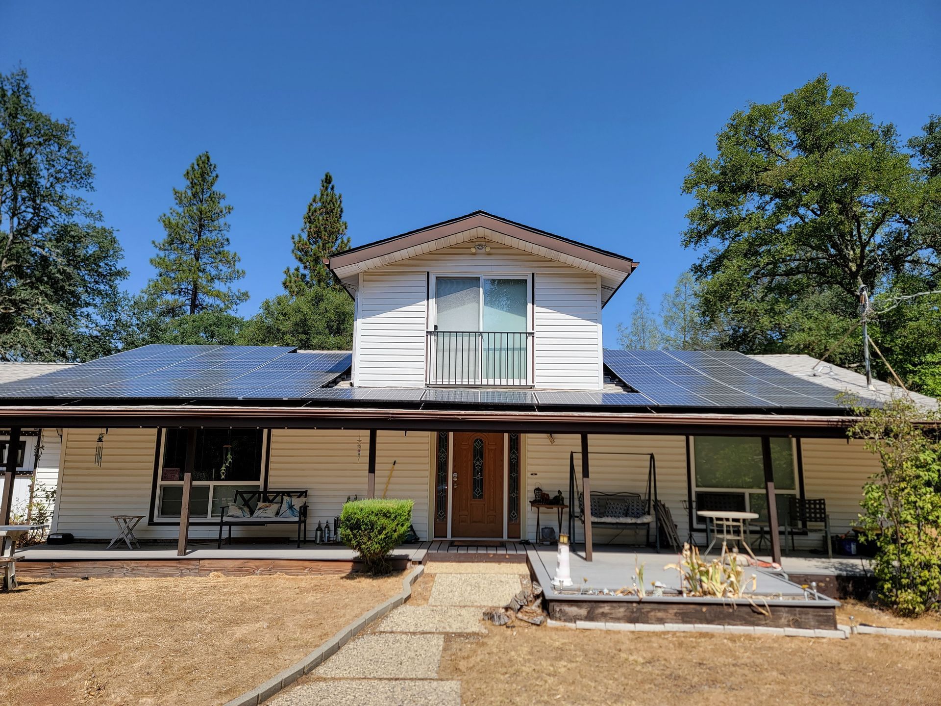 Home in the country with solar panels on lower roof level.