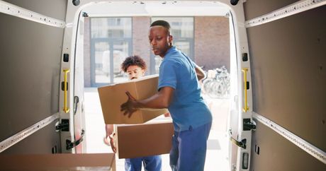 two men are loading boxes into a van