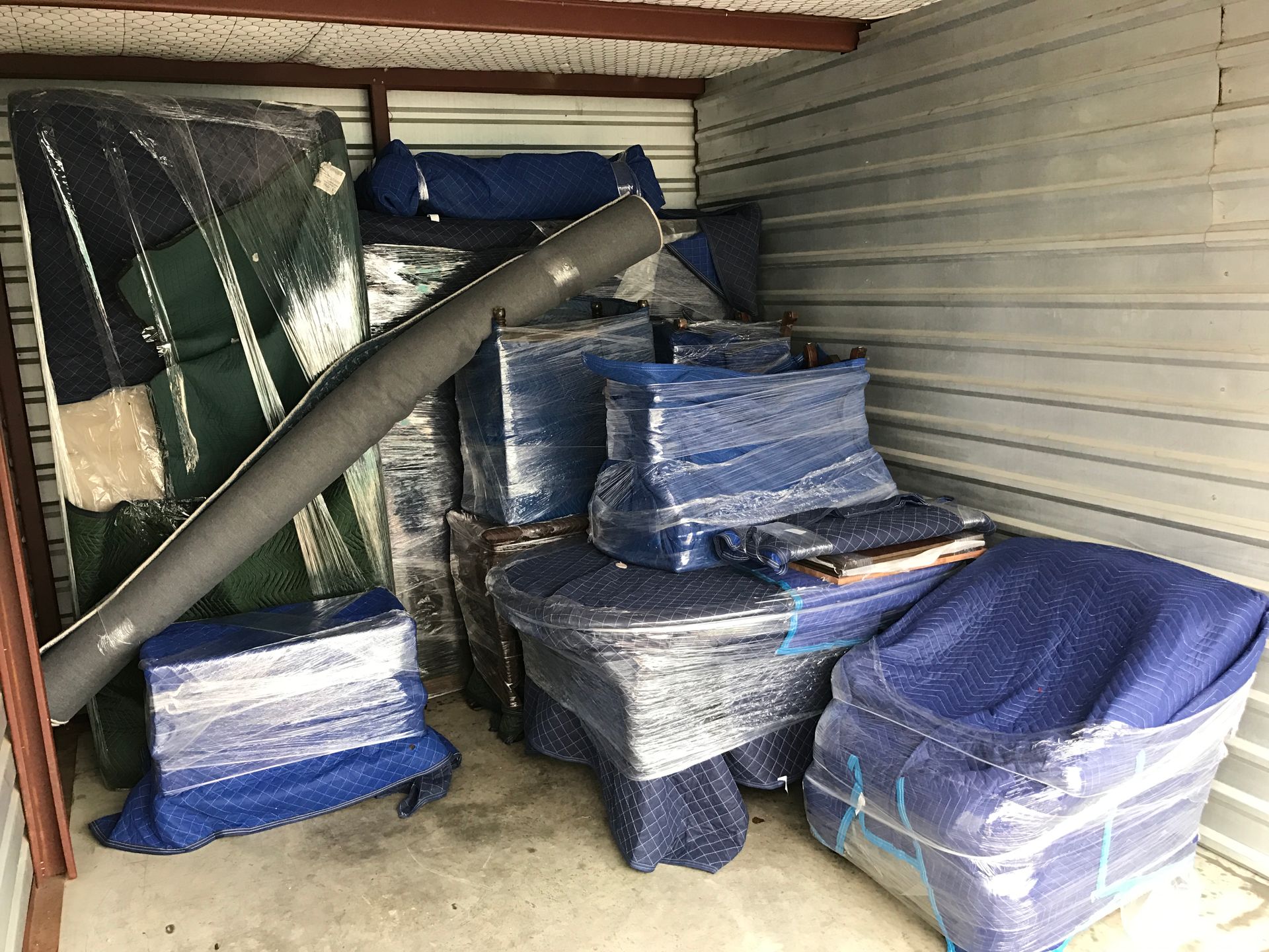 a room filled with lots of boxes wrapped in blue plastic
