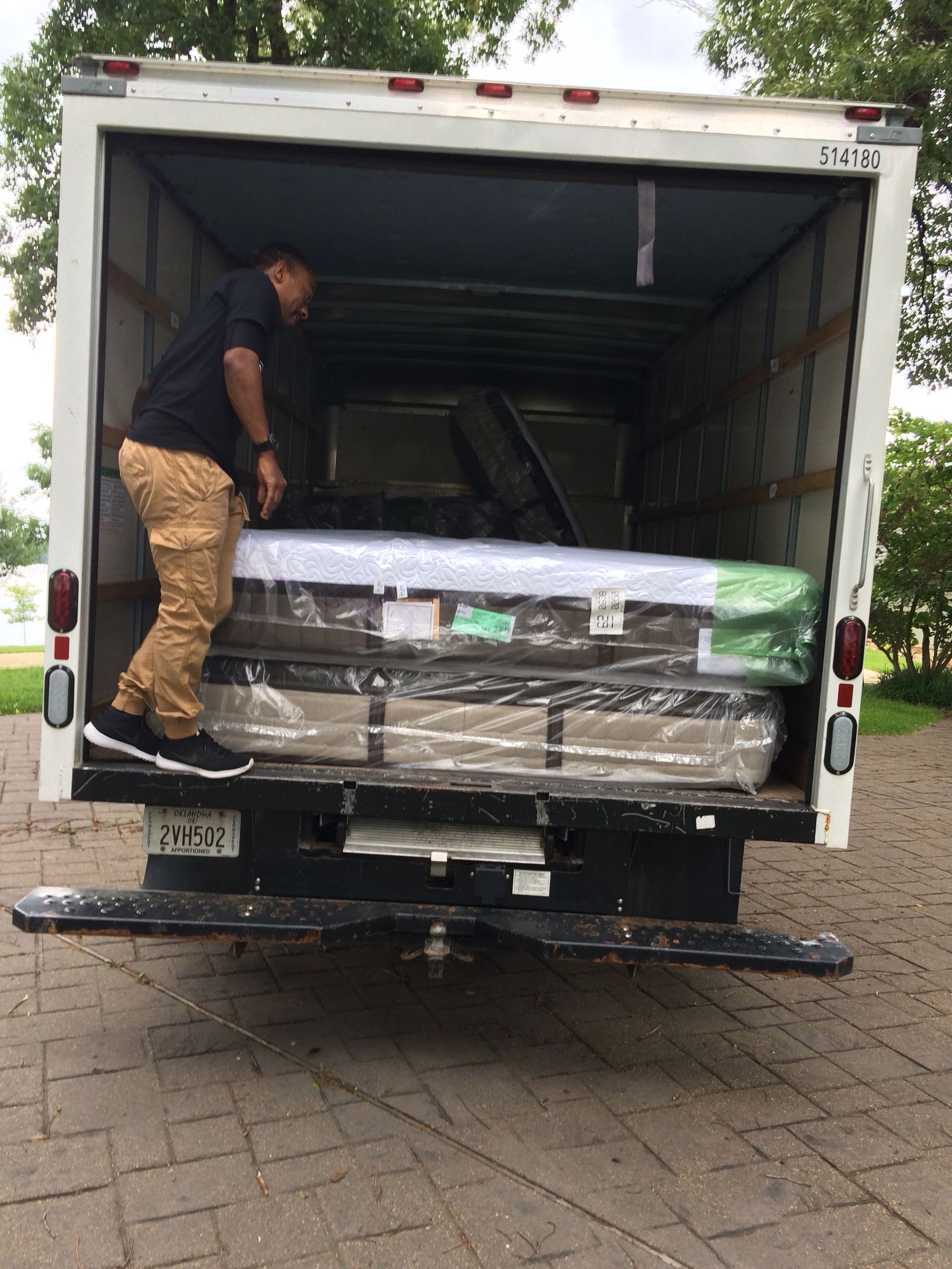 a man is loading a mattress into the back of a truck