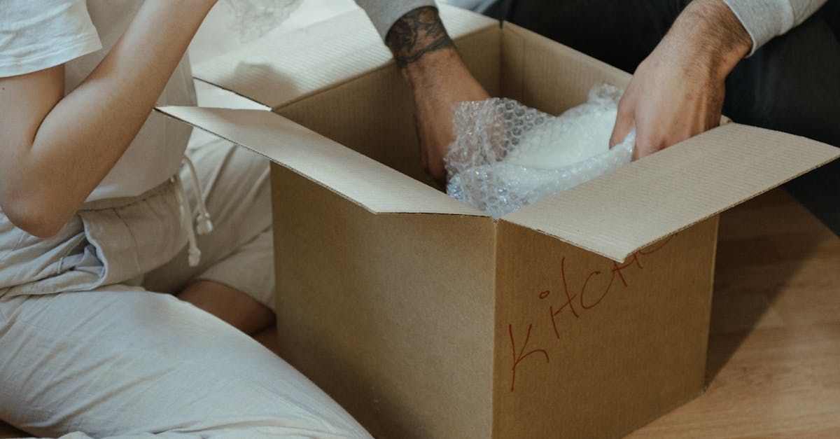 two movers are holding a chair and a rug in front of a van