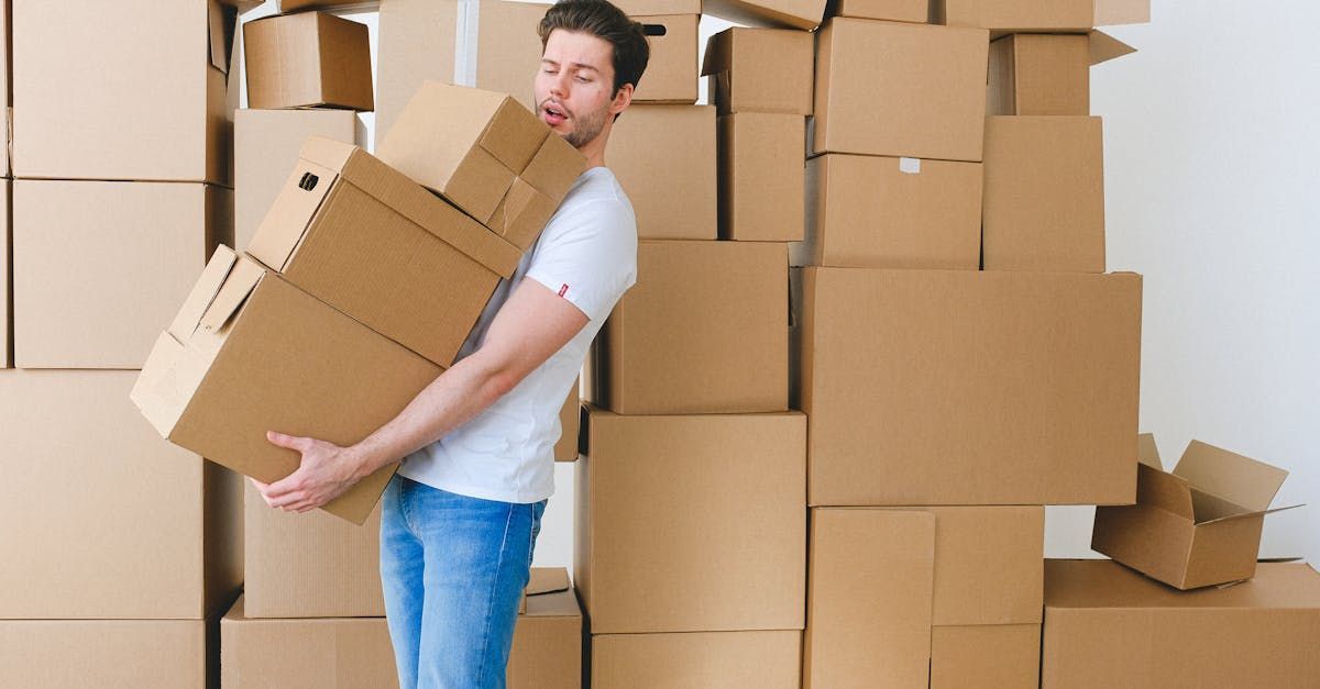 two movers are holding a chair and a rug in front of a van