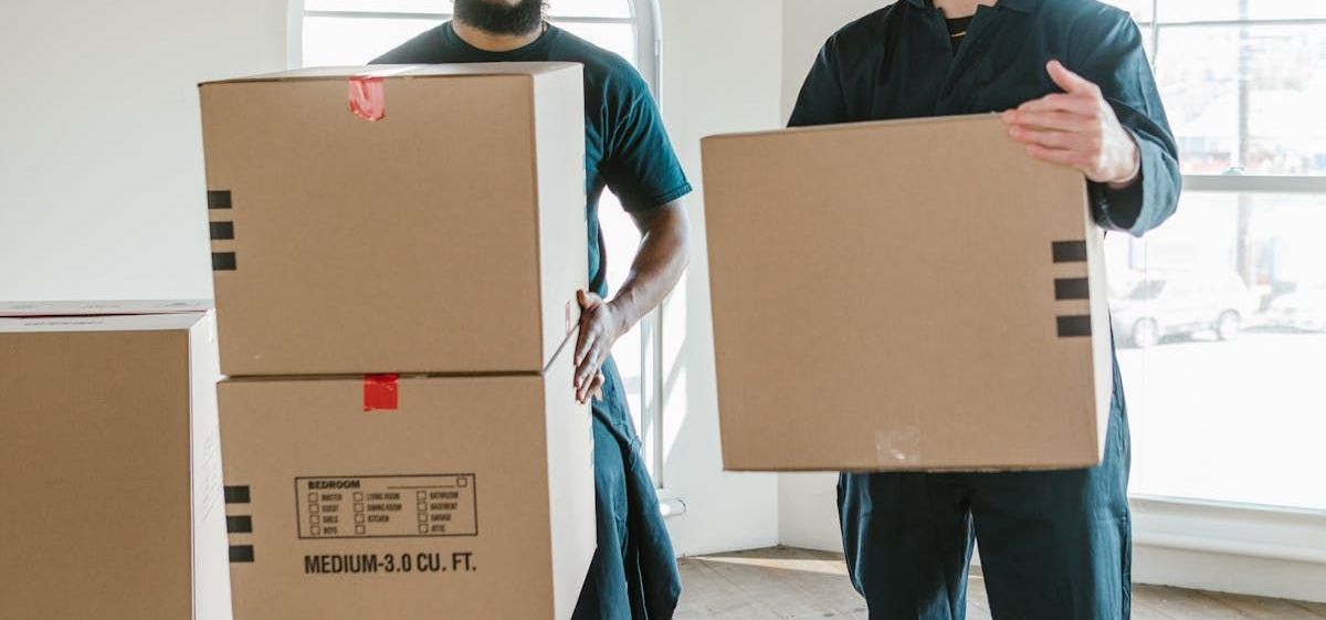 two men are loading boxes into a van