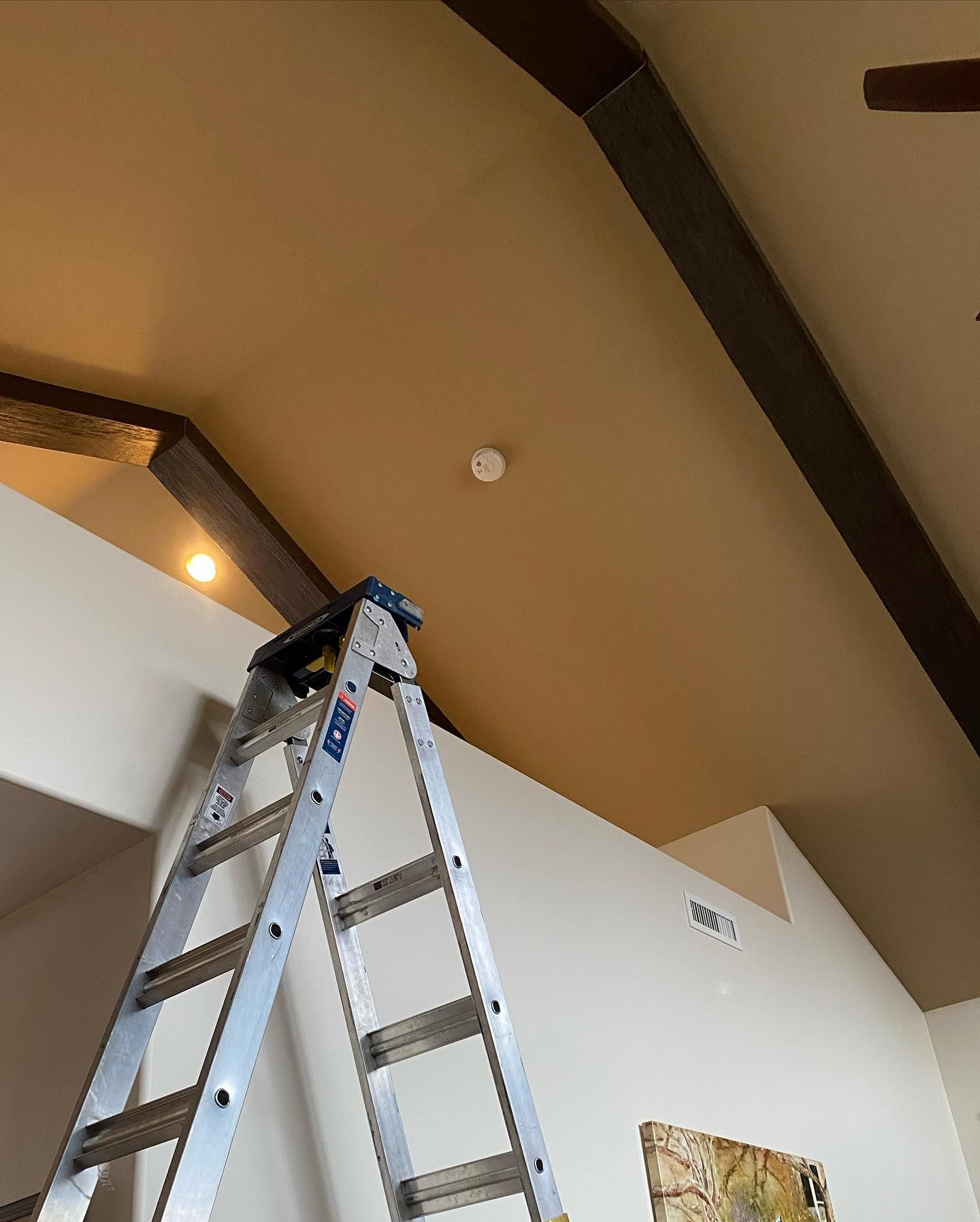 A ladder in a room with a ceiling fan