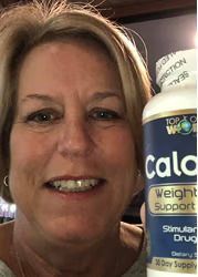 Woman smiling, holding a bottle of "Calo" weight support supplement. Bottle is blue and white.