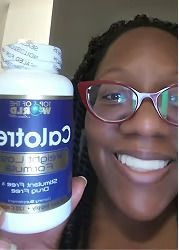 Person smiling, holding a bottle of "Calotren" weight loss supplement, blue and white label.